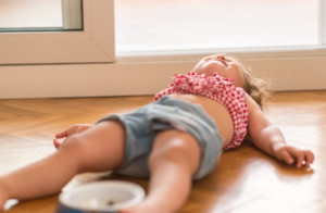 Niña tumbada en el suelo por una rabieta